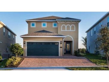 Charming two-story home featuring a brick driveway and a two-car garage, complemented by neat landscaping at 291 Pendant Ct, Kissimmee, FL 34747