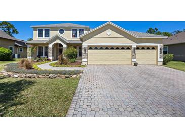 Stunning two-story home with a three-car garage, paver driveway and walkway, and beautifully landscaped front yard at 3428 Deer Oak Cir, Oviedo, FL 32766