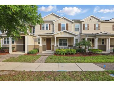 Charming tan two-story townhome with manicured lawn and covered front porch at 5892 Soter Ln, Windermere, FL 34786