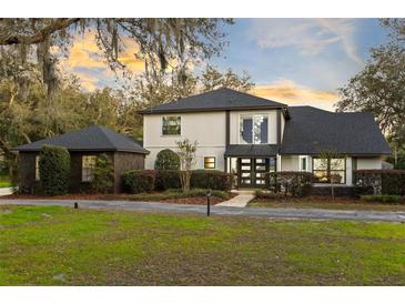 Attractive two-story home showcasing mature landscaping and a welcoming entrance enhanced by exterior lighting at 835 Dyson Dr, Winter Springs, FL 32708