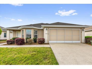 Charming single-story home featuring a well-maintained lawn and a two-car garage at 8602 Se 133Rd Ln, Summerfield, FL 34491