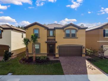 Charming two-story home with a tile roof, brick paved driveway, well-manicured lawn and a two car garage at 8892 Bengal Ct, Kissimmee, FL 34747