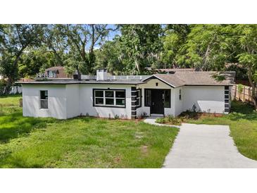 Charming white home featuring a well-manicured lawn and contrasting black trim accents at 239 S Lake Cortez Dr, Apopka, FL 32703
