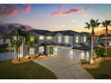 Stately home with three-car garage, manicured landscaping and tall palm trees at sunset at 3209 Waterbridge Ct, Kissimmee, FL 34744