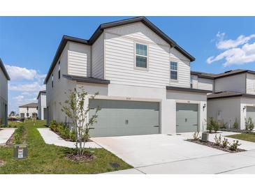 New construction home with a two car garage and a professionally landscaped yard at 854 Poppy Ln, Dundee, FL 33838