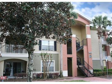 Charming condo building featuring a private balcony, stairs to upper floors, and lush tropical landscaping at 1969 Summer Club Dr # 209, Oviedo, FL 32765