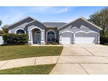 Charming single-story home featuring a well-manicured lawn and an attached two-car garage at 3469 Foxton Ct, Oviedo, FL 32765