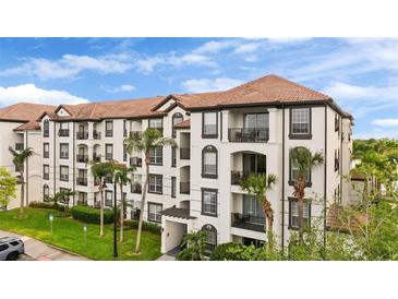 Beautiful condo building with a red tile roof and multiple balconies surrounded by green landscaping and palm trees at 4114 Breakview Dr # 11002, Orlando, FL 32819