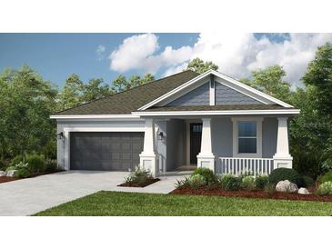 Charming single-Gathering home featuring a two-car garage, manicured lawn, and welcoming front porch at 4147 Coral Harbour Rd, Kissimmee, FL 34758