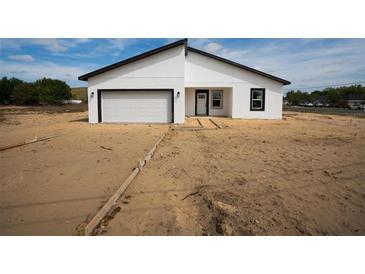New construction home features a modern exterior, two-car garage, black trim and a minimalist design at 55 Laurel Crse, Ocala, FL 34480