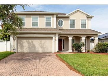 Charming two-story home showcasing a brick driveway, attached two-car garage, and welcoming front porch at 563 Copperdale Ave, Winter Garden, FL 34787