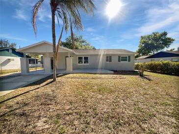 Charming single-story home with a front yard, carport, and inviting curb appeal on a sunny day at 800 Marion Dr, Mount Dora, FL 32757