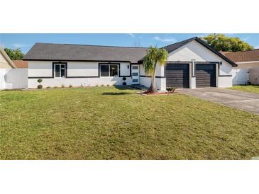 Charming single-story home with a well-manicured lawn, black trim and a two-car garage at 8143 Britt Dr, Orlando, FL 32822