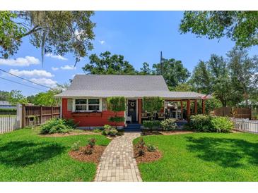 Charming red single-story home with inviting brick pathway and well-manicured lawn, blending curb appeal and comfort at 1010 N Clayton St, Mount Dora, FL 32757