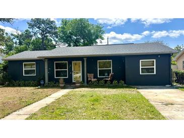 Charming single-story home with a dark exterior, welcoming front porch, and well-maintained lawn at 1098 Henry Balch Dr, Orlando, FL 32810