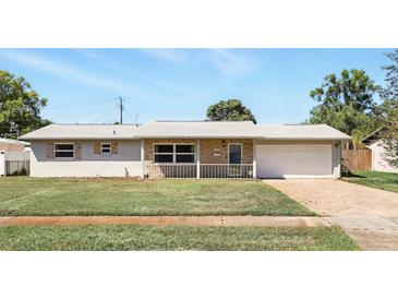 Charming single-story home with brick accents, a covered porch, a driveway, and well-maintained landscaping at 1109 Beatrice Dr, Orlando, FL 32810