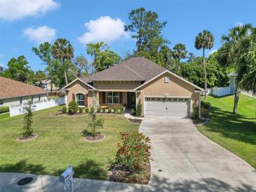 Inviting single-story home featuring lush landscaping, a well-manicured lawn, and a two-car garage, showcasing great curb appeal at 1819 Sw 29Th St, Ocala, FL 34471