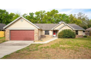 Charming single-story home with a red garage door, neat landscaping and a welcoming front entrance at 2132 Majestic Woods Blvd, Apopka, FL 32712