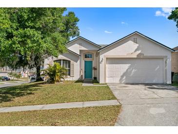 Charming single-story home with a well-manicured lawn and a bright blue front door at 6749 Westlake Blvd, Orlando, FL 32810