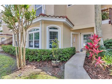 Inviting condo exterior featuring a beige facade, bay window, and lush landscaping at 980 Mooring Ave # 105, Altamonte Springs, FL 32714
