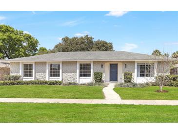 Charming single-story home featuring a stone facade, well-manicured lawn, and a welcoming blue front door at 1011 Terry Dr, Altamonte Springs, FL 32714