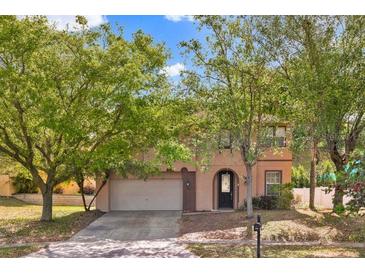 Charming two-story home with a well-maintained lawn and mature trees providing shade and curb appeal at 1037 Sailing Bay Dr, Clermont, FL 34711
