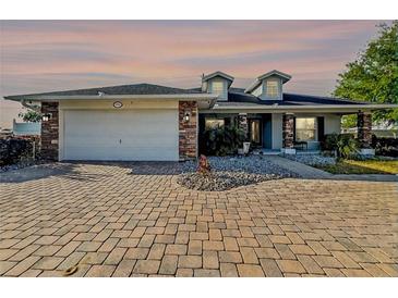 Charming single Gathering home boasts stone accents, dormer windows and a brick paved driveway at 104 Bentley Oaks Blvd, Auburndale, FL 33823