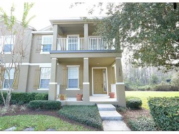 Charming two-story home featuring a porch and second story balcony and beautifully landscaped front yard at 10852 Spider Lily Dr # S, Orlando, FL 32832