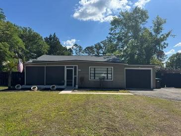 Charming single-story home with a well-maintained lawn and mature trees at 1433 Kingston Ave, Orlando, FL 32807