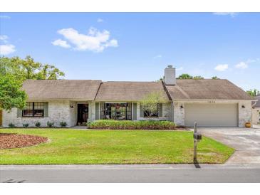 Charming single-story home features a well-manicured lawn and beautiful landscaping at 1558 Regal Oak Dr, Kissimmee, FL 34744