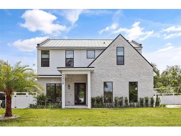 Stunning two-story home with modern architecture, brick accents, manicured lawn, and a sleek metal roof at 2408 Lafayette Ave, Winter Park, FL 32789