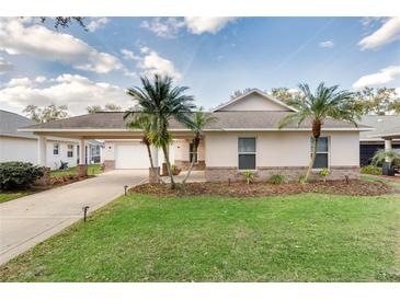 Charming home boasts a well-manicured lawn, complete with palm trees and a covered driveway with garage at 4087 Clock Tower Dr, Port Orange, FL 32129
