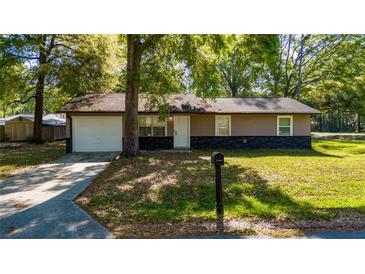Charming single-story home with a manicured lawn, attached garage and stone accents enhancing its curb appeal at 5 Redwood Trace Run, Ocala, FL 34472