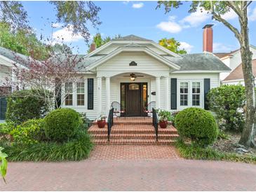 Charming home featuring a brick walkway, covered entry, white columns, and meticulous landscaping at 525 Sheridan Blvd, Orlando, FL 32804