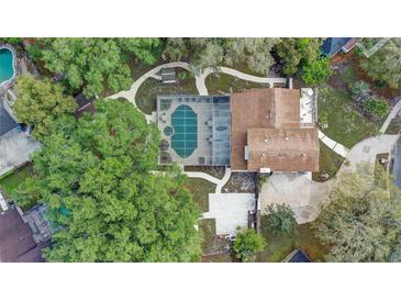 Aerial view of a home featuring a screened-in pool, lush landscaping, and winding walkways at 1204 Swan St, Winter Springs, FL 32708