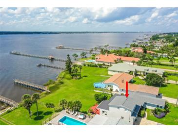 Stunning waterfront property with a pool, lush lawn, and a private dock, offering picturesque views of the water at 3168 S Peninsula Dr, Daytona Beach, FL 32118