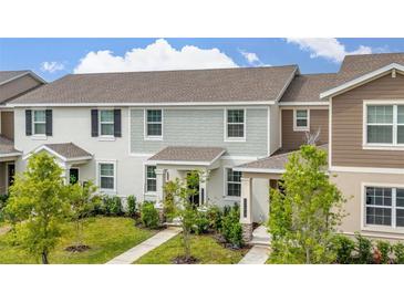 Exterior showcasing a neat lawn and neutral-tone facade with stylish architectural detail at 10684 Words Dr, Winter Garden, FL 34787