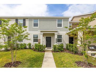 Charming two-story home featuring a well-maintained lawn, walkway, and neutral-tone exterior at 10684 Words Dr, Winter Garden, FL 34787