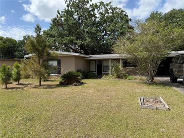 Charming single-story home featuring a well-maintained lawn and mature trees, perfect for curb appeal at 1528 Baltimore Dr, Orlando, FL 32810