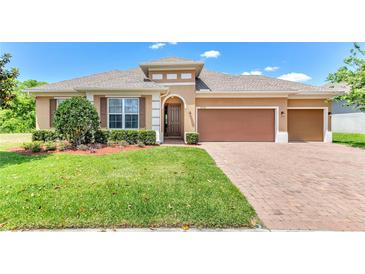 Charming single-story home with a well-manicured lawn, brick driveway, and two-car garage at 2724 Westyn Cove Ln, Ocoee, FL 34761