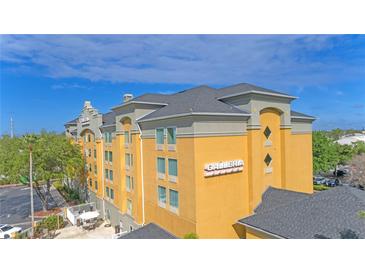 Stylish yellow Galleria hotel with gray trim, blue sky and roof at 3000 Maingate Ln # 504, Kissimmee, FL 34747