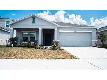 Charming single-story home with a well-manicured lawn and a two-car garage at 33891 Sky Blossom Cir, Leesburg, FL 34788