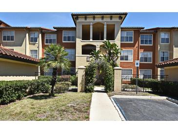 Inviting condo complex entrance with lush landscaping, decorative archway, and convenient parking access at 5578 Metrowest Blvd # 10, Orlando, FL 32811