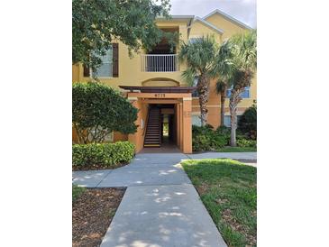 Exterior view of the condo complex with landscaping and walkway at 8775 Sartori St # 302, Orlando, FL 32829