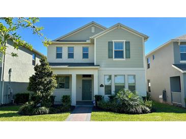 Charming two-story home with manicured lawn and welcoming front porch, perfect for relaxing outdoors at 11015 Bostwick Aly, Winter Garden, FL 34787