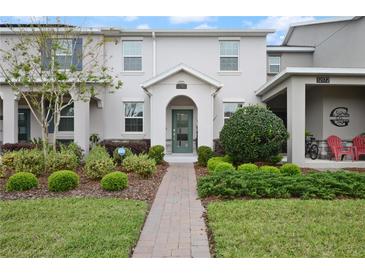 Charming townhome featuring lush landscaping, brick walkway and a welcoming front entrance at 12180 Sonnet Ave, Orlando, FL 32832
