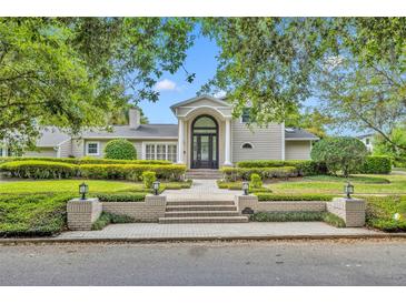 Inviting home featuring manicured landscaping, a brick walkway and a grand arched front door at 1370 Alberta Dr, Winter Park, FL 32789