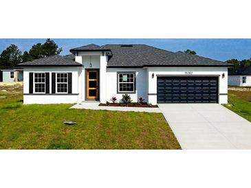 Charming single-story home featuring a modern design, attached garage, and fresh landscaping at 15282 Sw 65Th Avenue Rd, Ocala, FL 34473