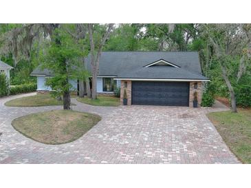 Charming single-story home with a brick-lined driveway and a two-car garage at 1845 Spruce Creek Blvd, Port Orange, FL 32128