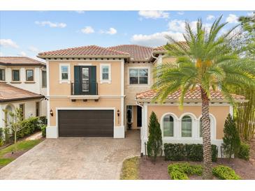 Stunning two-story home featuring a tile roof, balcony, arched windows, and a lush, landscaped yard with a palm tree at 3144 Players View Cir, Longwood, FL 32779